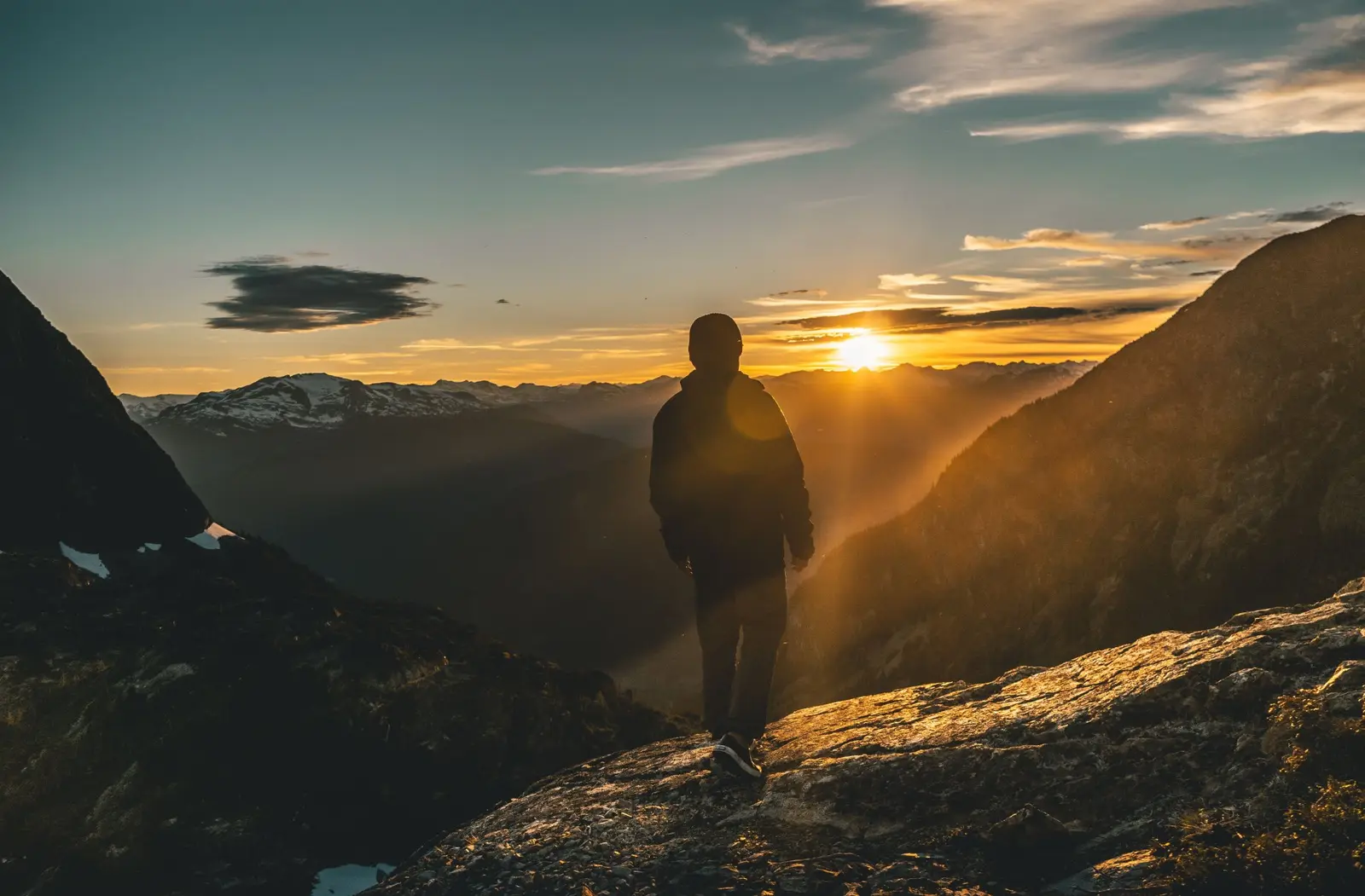 A traveller pausing on a sunlit coastal path at golden hour